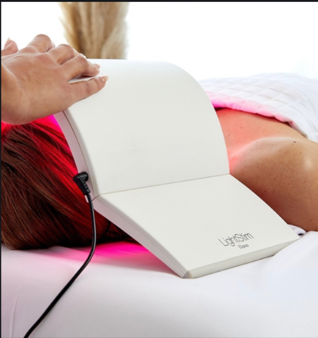 Person using a LightSlim device on their leg with visible branding.